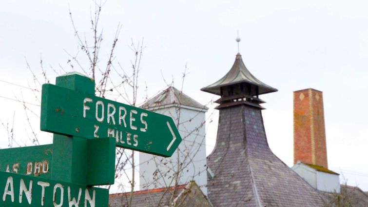 green sign pointing to forres